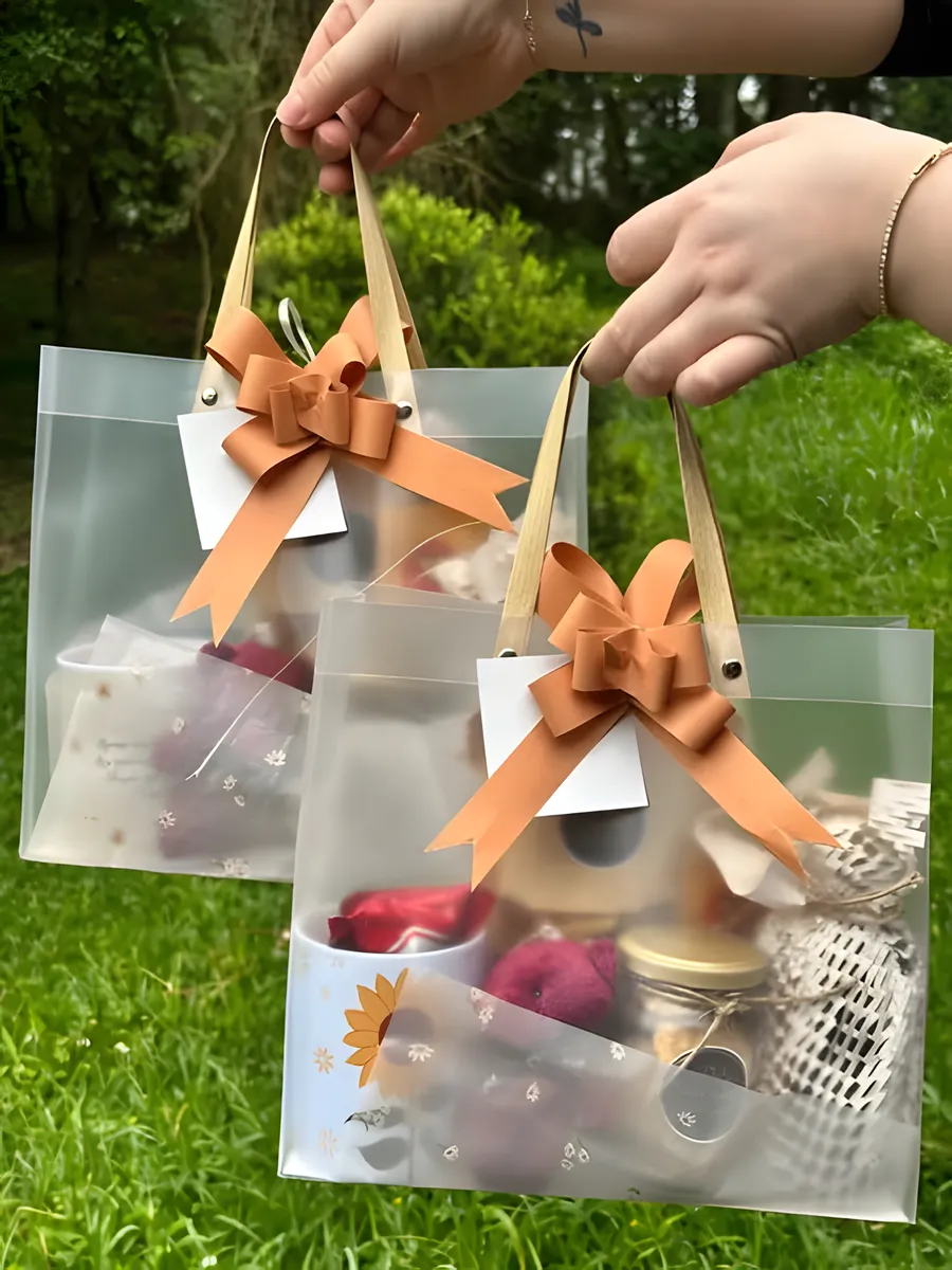 Duas sacolas de presente com laço cobre, montadas com itens personalizados
